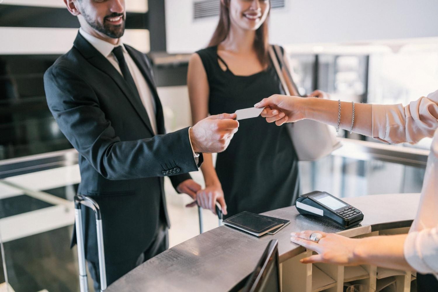 Hotel receptionist handing a key card to a guest at a UAE hotel front desk